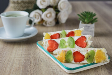 Japanese dessert fruit sandwich with a glass of matcha tea served on a wooden table