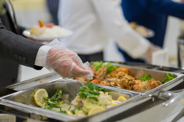 closeup hand wearing gloves scooping food, catering, dinner time, prevent Coronavirus disease (covid 19)