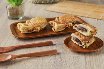 Taiyaki Japanese street food sweet fish-shaped waffle served on a wooden table