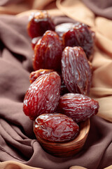 Juicy dates on the table with satin.