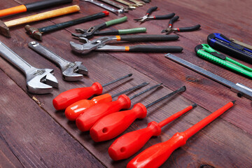 Variety of repairman tools for repair work on wooden background.