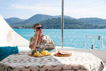 Caucasian businessman using mobile phone and working on digital tablet for online corporate...