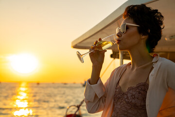 Caucasian woman enjoy outdoor luxury lifestyle with drinking champagne while catamaran boat sailing...