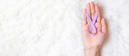 World cancer day (February 4). Woman hand hoy Lavender purple ribbon for supporting people living...