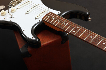 Fototapeta na wymiar Guitar tube combo amplifier with electric black guitar on black background.