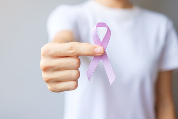 World cancer day (February 4). Woman hand holding Lavender purple ribbon for supporting people...