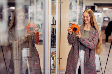 Smiling customer with eyeglasses shopping instant camera in store