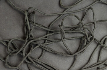 Black rope chaotically on a black background.