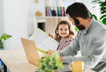 Smiling girl showing drawing to father working at home