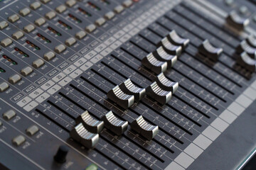 Faders and control buttons on the mixing console. Selective focus