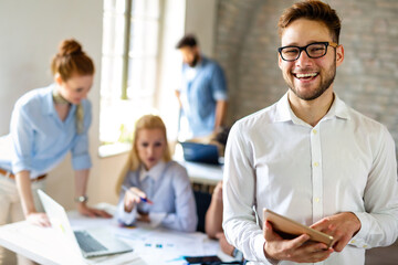 Portrait of happy successful business people working on tablet in office. Business teamwork concept