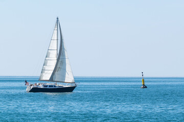 Obraz premium Voilier qui navigue sur la mer bleu avec une bouée