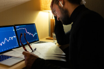 Frustrated trader looking at graph data on laptop