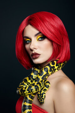 Beautiful woman with red hair and a yellow python snake around her neck. Professional Bright Beauty Eye Makeup Yellow, Red Burgundy Lipstick