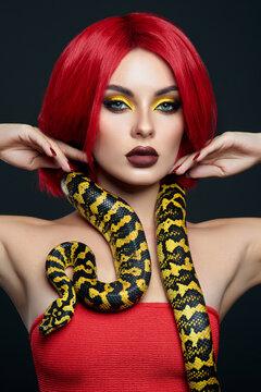 Beautiful woman with red hair and a yellow python snake around her neck. Professional Bright Beauty Eye Makeup Yellow, Red Burgundy Lipstick