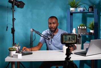 Content creator adjusting volume on mixer console in front of live vlog setup in online morning...