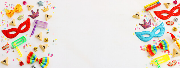 Purim celebration concept (jewish carnival holiday) over wooden white background. Top view, flat lay