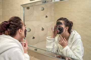 black mask with minerals and components applied to the girl's face.