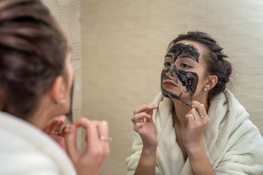 beauty near the mirror removes a black mask film from black dots in the bathroom.