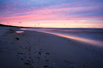 sunset on the baltic coast with purple clouds in the sky.