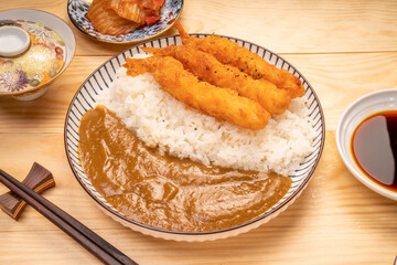 Japanese food curry rice with fried shrimp tempura on wooden table, Traditional Japanese food.