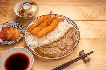 Japanese food curry rice with fried shrimp tempura on wooden table, Traditional Japanese food.