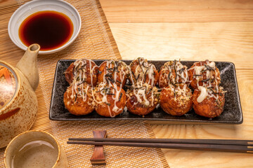 Japanese food Takoyaki octopus balls with takoyaki sauce on wooden table, Traditional Japanese food.