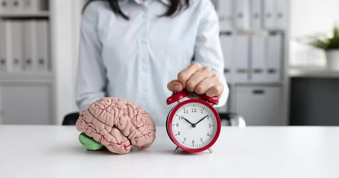 Head puts red alarm clock with brain layout