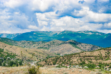 View from the highway to the mountain plateau Karabi-Yayla. Crimean landscape with mountains, vineyards and blue sky with cirrus clouds.