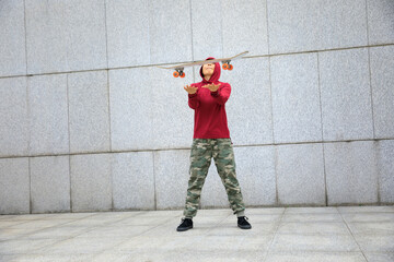 Skateboarder with skateboard outdoors in city