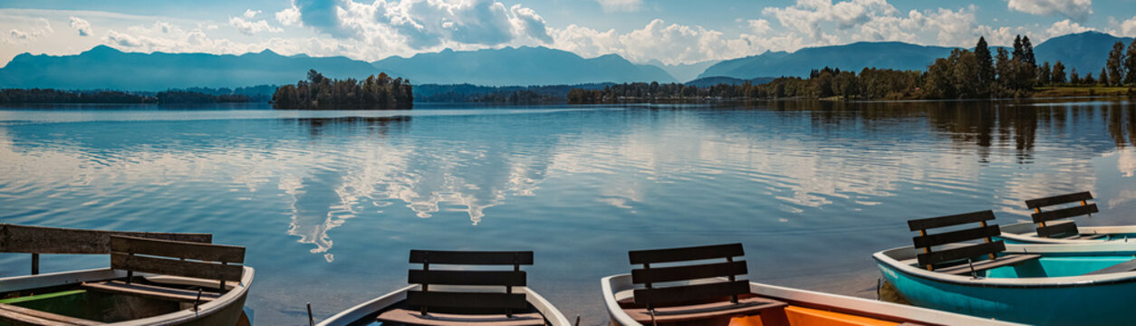 High resolution stitched panorama with reflections and rowboats at the famous Staffelsee lake, Seehausen, Bavaria, Germany