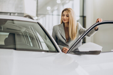 Attractive woman in car showroom buying a car