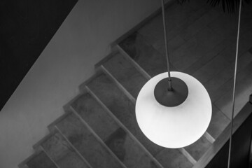 Round pendant lamp with stairs at the bottom. Horizontal view. Black and white.