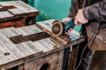 Grinding burrs and metal with an angle grinder with sparks.