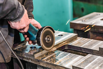 Grinding burrs and metal with an angle grinder with sparks.