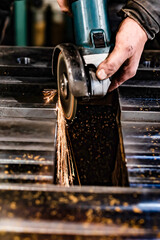 Grinding burrs and metal with an angle grinder with sparks.