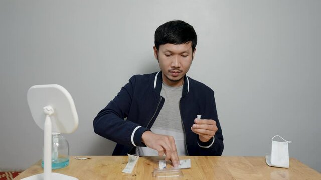 4k, Asian man uses rapid antigen test kit to detect COVID-19 by yourself at home Preparing to test the infection of the virus will prevent the spread of the virus itself.