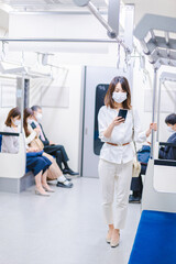 Fototapeta na wymiar マスクをして電車にのる女性