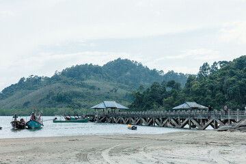Fototapeta premium Pier in National park with local fishing boats in Kapur District, Ranong, Thailand from aerial view by drone.