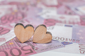 Two hearts flat lay on the 500 five hundred cash money pile paper blurred background.Selective...