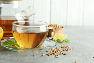 Concept of hot drink with buckwheat tea on gray textured table