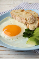 Plate of tasty breakfast on white wooden background