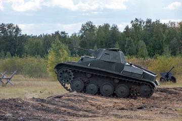 Attack of the Soviet tank T25. Tank moving through the fortification, ditch. Reconstruction of the battle of World War II. Russia, Chelyabinsk region, September 12, 2021 Victory Day.