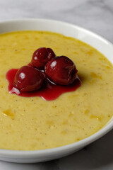 Vanilla flummery with cherries, in a porcelain bowl. Vanilla custard. 