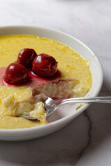 Vanilla flummery with cherries, in a porcelain bowl. Vanilla custard. 
