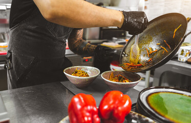 Professional chef cooking in the kitchen restaurant at the hotel, preparing dinner.