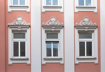 Fototapeta na wymiar three historic windows with stucco ornate above