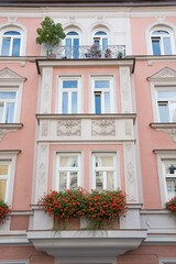 Fototapeta na wymiar historic house facade munich, with balcony, jutties and geranium flowers