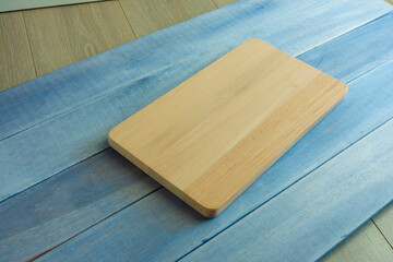 Tabla de cortar sobre madera azul. Cutting board on blue wood.