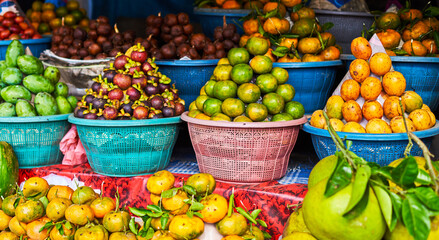 Stall of organic vegetables and fruits at a farmers market. Selling organic fresh agricultural product at farmer market. All kinds of asian fruits on a market in Bali, Indonesia.